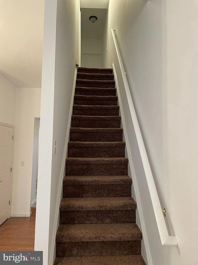 stairway featuring wood finished floors and baseboards