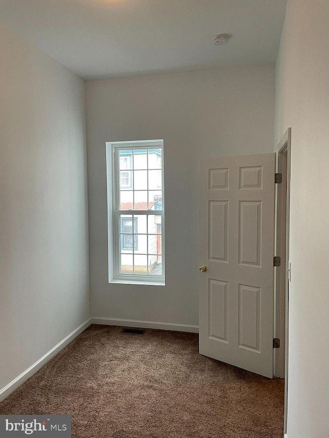 unfurnished room featuring carpet flooring, a smoke detector, and baseboards