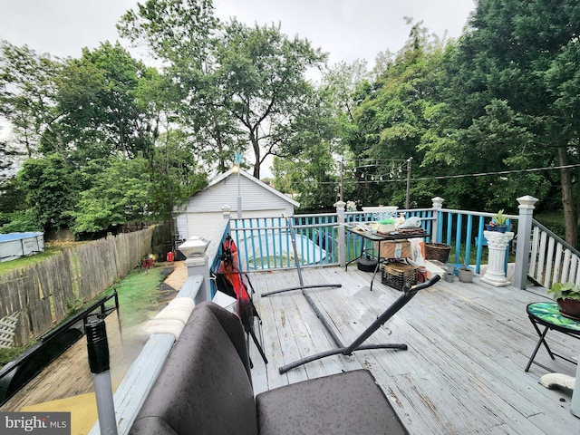 35 W Montrose St, Vineland, NJ 08360 - deck with an outdoor structure, fence, view of wooded area, and a detached garage