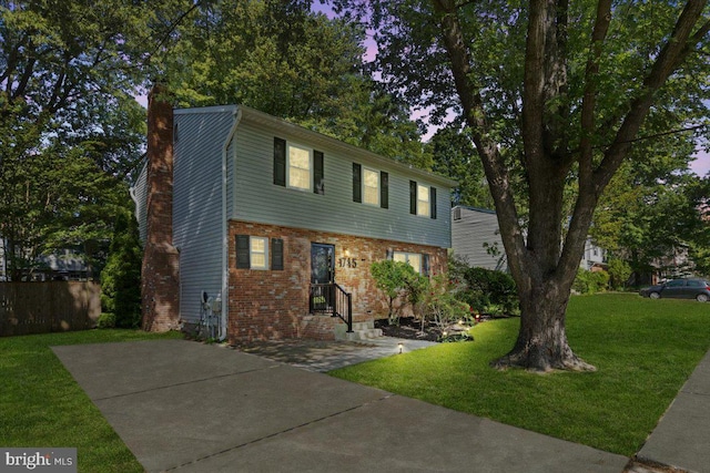 1745 Remington Dr, Crofton, MD 21114 - colonial inspired home featuring a chimney, brick siding, and a front lawn