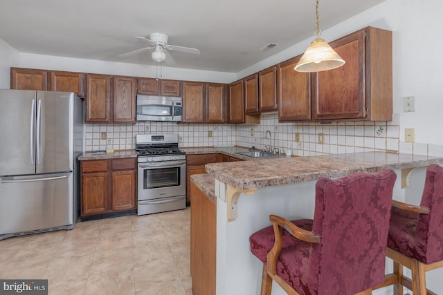 217 Pratt Ct, Sewell, NJ 08080 - kitchen with appliances with stainless steel finishes, tasteful backsplash, a peninsula, ceiling fan, and pendant lighting