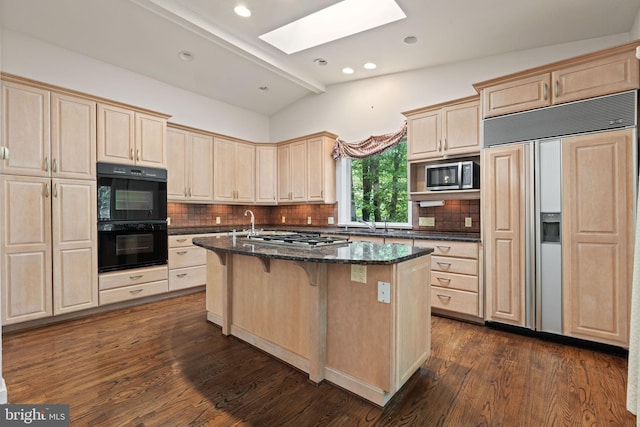 6802 Nesbitt Pl, Mclean, VA 22101 - kitchen featuring appliances with stainless steel finishes, a skylight, light brown cabinetry, a kitchen island with sink, and recessed lighting