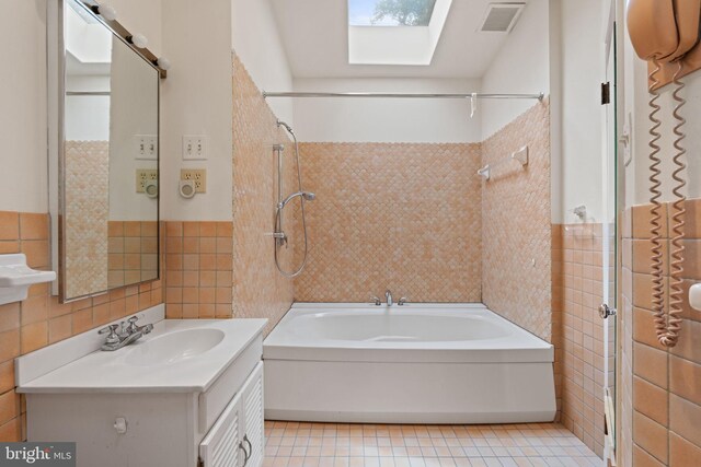 6802 Nesbitt Pl, Mclean, VA 22101 - bathroom featuring tile walls, vanity, washtub / shower combination, tile patterned floors, and a skylight