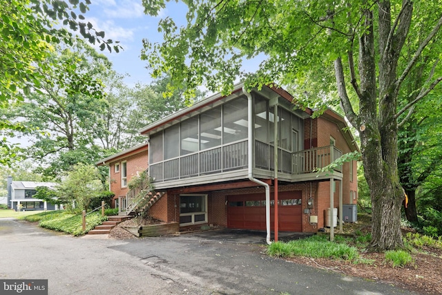 6802 Nesbitt Pl, Mclean, VA 22101 - view of front of house with brick siding, a sunroom, a garage, asphalt driveway, and stairs
