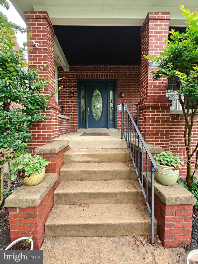doorway to property featuring brick siding