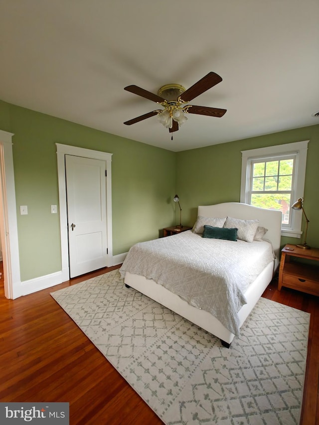 bedroom with wood finished floors, baseboards, and ceiling fan