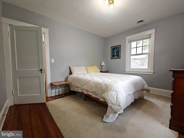 bedroom with baseboards and wood finished floors
