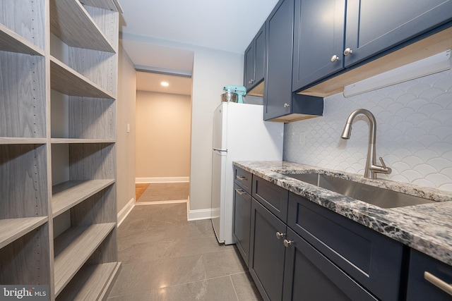 1919 Chestnut St Unit 523-524, Philadelphia, PA 19103 - kitchen featuring a sink, decorative backsplash, light stone countertops, baseboards, and open shelves