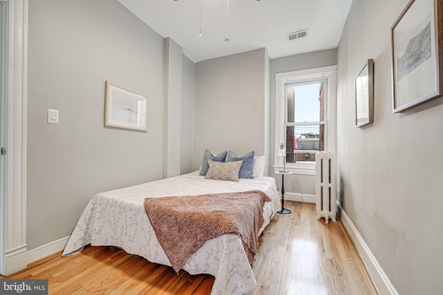 1823 4th St NW, Washington, DC 20001 - bedroom with light wood-type flooring, baseboards, attic access, and radiator heating unit