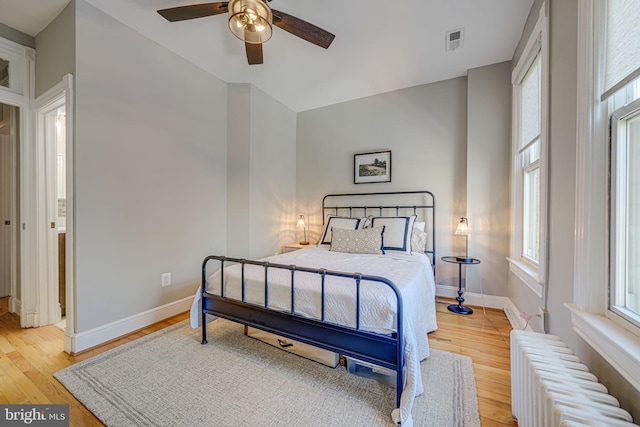 1823 4th St NW, Washington, DC 20001 - bedroom with radiator heating unit, light wood-type flooring, and multiple windows