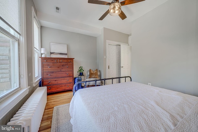 1823 4th St NW, Washington, DC 20001 - bedroom featuring radiator heating unit, light wood finished floors, ceiling fan, and a closet