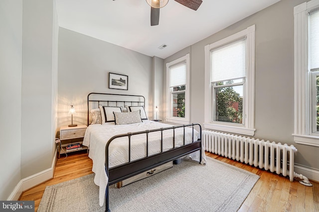 1823 4th St NW, Washington, DC 20001 - bedroom with radiator heating unit, light wood-style flooring, ceiling fan, and baseboards