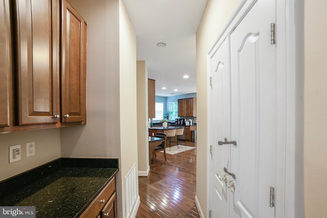 corridor featuring dark wood finished floors, recessed lighting, and baseboards