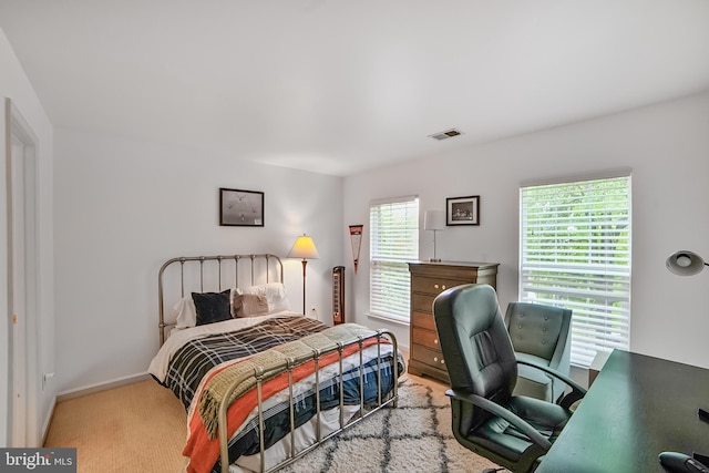 carpeted bedroom with a desk and baseboards