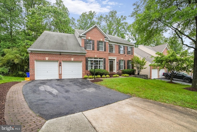 view of front of home featuring a garage, brick siding, driveway, and a front yard