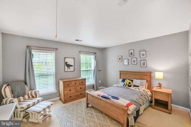 bedroom with baseboards and light carpet