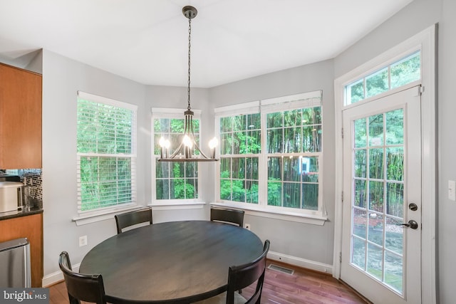 dining space featuring baseboards, wood finished floors, and a chandelier