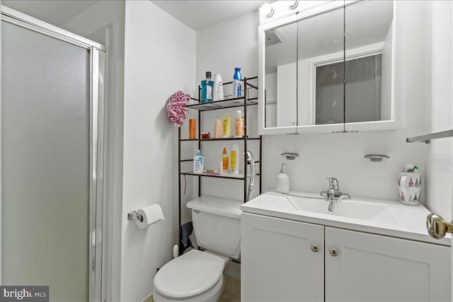 bathroom with toilet, a stall shower, and vanity