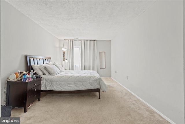 bedroom with a textured ceiling, carpet, and baseboards