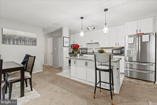 kitchen featuring stainless steel fridge with ice dispenser, light carpet, a kitchen island, and white cabinetry