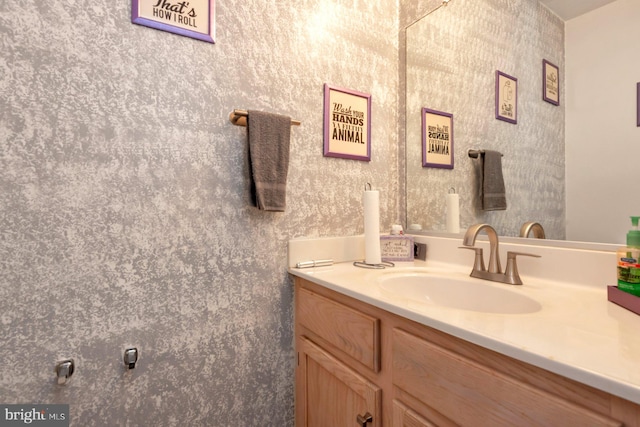 bathroom with vanity and wallpapered walls