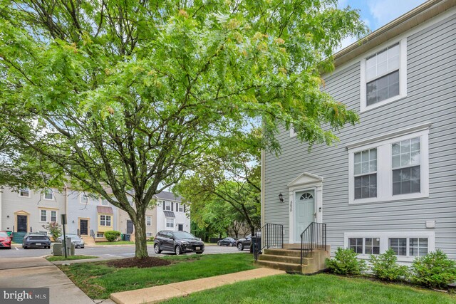 multi unit property featuring a residential view and a front lawn