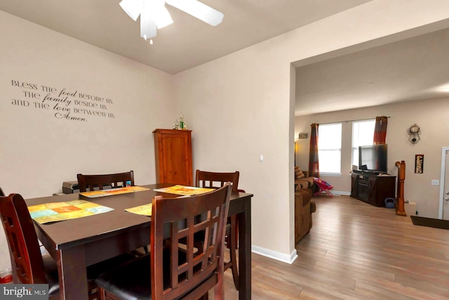 dining space featuring ceiling fan, light wood-type flooring, and baseboards