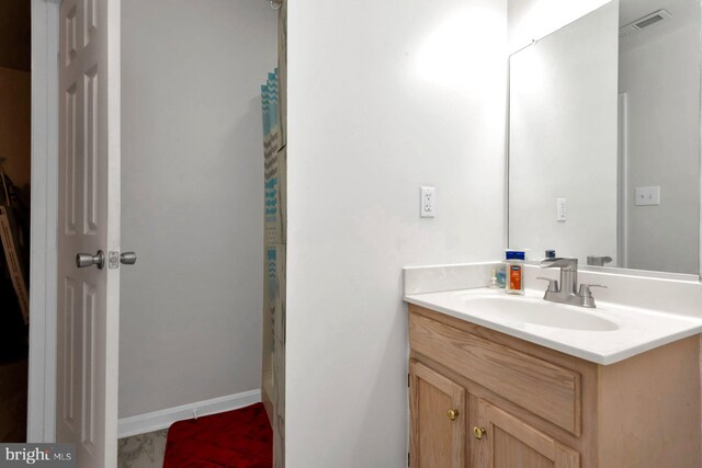 full bath with vanity, curtained shower, and baseboards