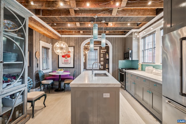 801 E Jefferson St, Charlottesville, VA 22902 - kitchen featuring stainless steel appliances, a sink, light wood-style flooring, gray cabinetry, and beam ceiling