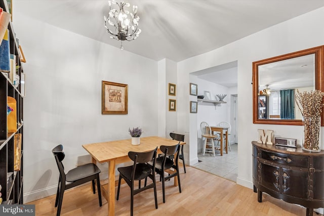 2429 S Reese St, Philadelphia, PA 19148 - dining space with light wood-style flooring, a chandelier, and baseboards
