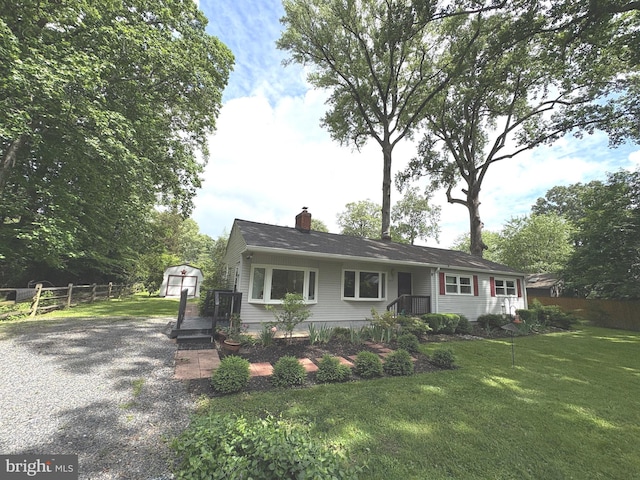 view of front of house with a storage shed, an outbuilding, and a chimney