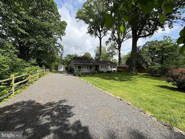 ranch-style home featuring a shed, driveway, and an outbuilding