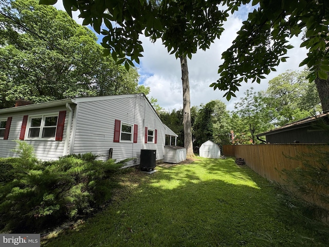 view of yard featuring a storage unit, central AC, and an outdoor structure