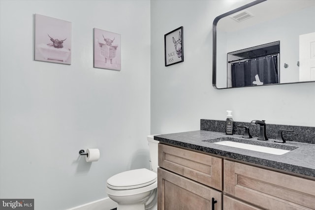 full bath with toilet, vanity, and baseboards