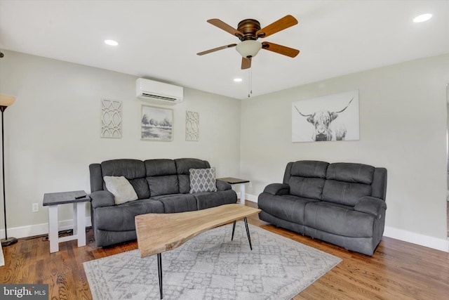 living area featuring a wall mounted air conditioner, a ceiling fan, wood finished floors, baseboards, and recessed lighting