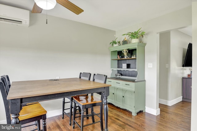 dining room featuring a wall mounted air conditioner, wood finished floors, a ceiling fan, and baseboards