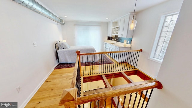 306 S Exeter St, Baltimore, MD 21202 - stairs with baseboards, wood finished floors, healthy amount of natural light, and recessed lighting