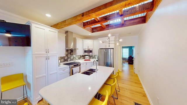 306 S Exeter St, Baltimore, MD 21202 - kitchen featuring a sink, appliances with stainless steel finishes, wall chimney range hood, tasteful backsplash, and light wood-type flooring
