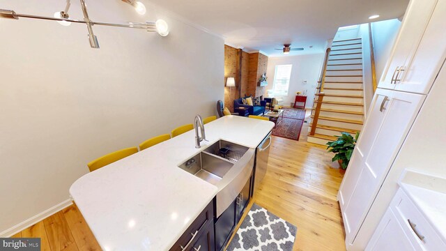 306 S Exeter St, Baltimore, MD 21202 - kitchen featuring light wood-style flooring, open floor plan, light countertops, ceiling fan, and a sink