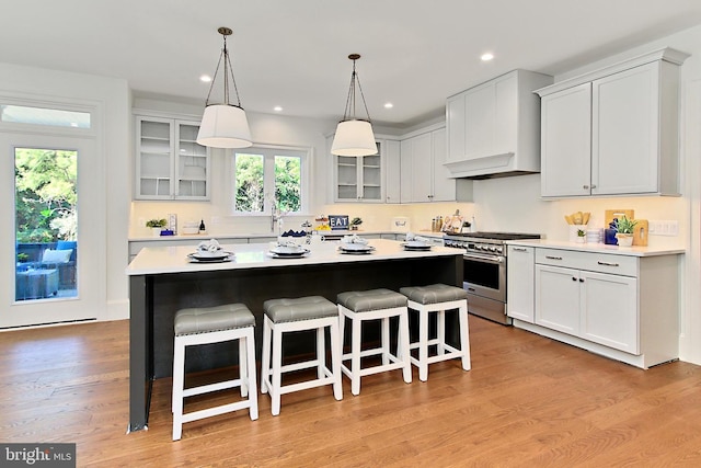 7430 Foundation Way, Springfield, VA 22150 - kitchen featuring stainless steel stove, a kitchen breakfast bar, a kitchen island, glass insert cabinets, and light countertops