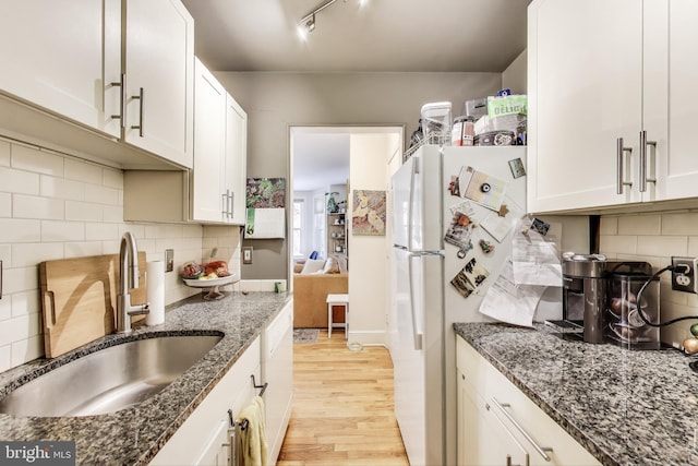 1324 10th St NW, Washington, DC 20001 - kitchen featuring a sink, light wood-style flooring, dark stone counters, and backsplash