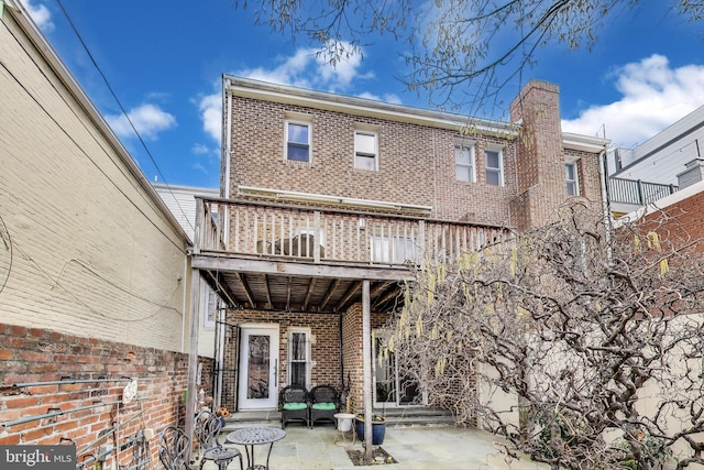 1324 10th St NW, Washington, DC 20001 - back of property with brick siding, a patio area, fence, and a chimney