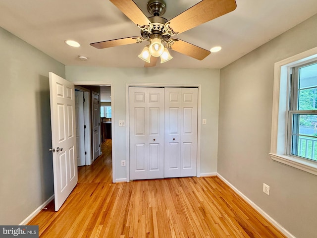 unfurnished bedroom featuring baseboards, light wood-type flooring, a closet, a ceiling fan, and recessed lighting