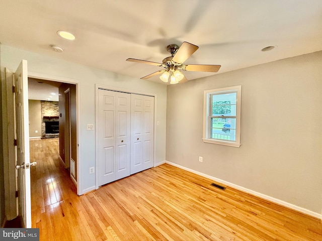 unfurnished bedroom with light wood-style flooring, baseboards, a closet, a ceiling fan, and recessed lighting