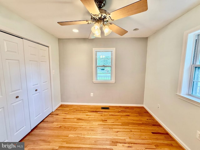 unfurnished bedroom with multiple windows, a closet, light wood-type flooring, baseboards, and recessed lighting
