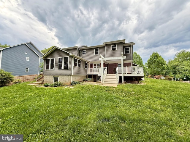 back of property with a wooden deck, a lawn, and stairway