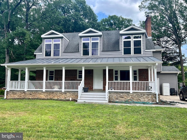 view of front of house with a standing seam roof, covered porch, a chimney, and brick siding