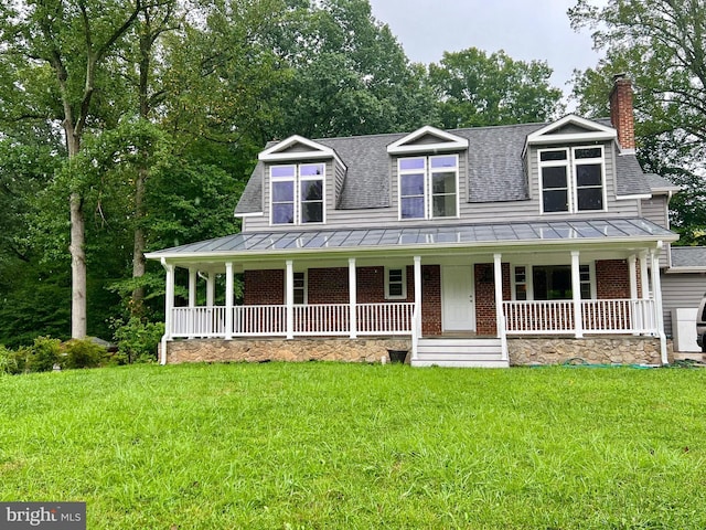 view of front of house featuring a standing seam roof, covered porch, roof with shingles, and a chimney