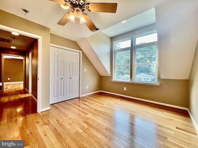 additional living space featuring light wood-style floors, a ceiling fan, and baseboards