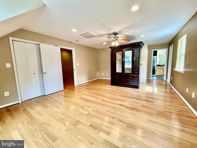 unfurnished bedroom with light wood-type flooring, baseboards, recessed lighting, attic access, and a ceiling fan